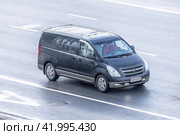 Hyundai H1 minibus is driving on the street, aerial front side view. Light commercial vehicle in motion. Редакционное фото, фотограф Константин Григорьев / Фотобанк Лори