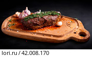 кусок аппетитного жареного мяса с овощами на доске. Стоковое AI-изображение, AI-художник Данил Хусаинов / Фотобанк Лори