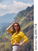 Lovely adult lady posing at Sri Lanka Adam's peak mountain in sight, landmark nature, looking at camera. Pretty woman in sunglasses enjoying at tropical journey, Ella, Sri Lanka. Copy ad text space (2022 год). Стоковое фото, фотограф Aleksandr Golubev / Фотобанк Лори