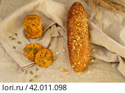 Печенье круглое домашнее злаковое постное, багет зерновой на кухонном льняном полотенце. Стоковое фото, фотограф Оксана Шведкова / Фотобанк Лори