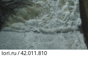 Водосброс на реке через старую плотину. Бурный поток серой воды. Движение камеры снизу вверх. Стоковое видео, видеограф Воловодов Владимир / Фотобанк Лори