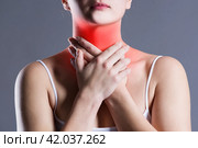 Sore throat, woman with pain in neck, gray background. Стоковое фото, фотограф Станислав Тарко / Фотобанк Лори