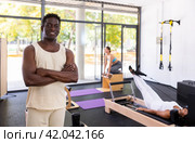 Positive African American man posing in fitness studio. Стоковое фото, фотограф Яков Филимонов / Фотобанк Лори