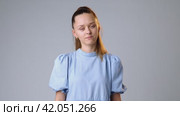 Young woman rejecting something with her hands on gray background. Стоковое видео, видеограф Сергей Толмачёв / Фотобанк Лори