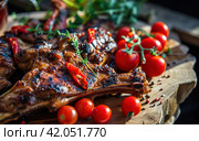 grilled meat with tomatoes, chilies and herbs on a wooden bbq. Стоковое AI-изображение, AI-художник Юлия Гапеенко / Фотобанк Лори
