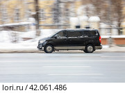 Hyundai Grand Starex minivan driving in the city street. Black minibus in motion, side view. Редакционное фото, фотограф Константин Григорьев / Фотобанк Лори