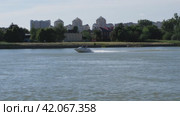 Белая скоростная моторная лодка плывет по реке на фоне города. Городской пейзаж. Стоковое видео, видеограф Воловодов Владимир / Фотобанк Лори