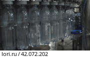 Крупный план налива воды в пластиковую бутылку объемом 1,5 литра в узле розлива. Цех по производству минеральной воды и безалкогольных напитков. Стоковое видео, видеограф Воловодов Владимир / Фотобанк Лори