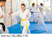 Teen girl is paired with male teacher to learn how to strike and rehearses blocking opponent. Стоковое фото, фотограф Яков Филимонов / Фотобанк Лори