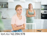 Offended teenage girl sitting in kitchen after disagreements with mother. Стоковое фото, фотограф Яков Филимонов / Фотобанк Лори