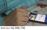 Девушка пролистывает информацию на экране телефона, лежащего на столе. Стоковое видео, видеограф Воловодов Владимир / Фотобанк Лори