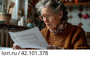 an senile woman looks at a document in front of a kitchen. Стоковое AI-изображение, AI-художник Юлия Гапеенко / Фотобанк Лори