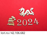 Новый год 2024. Цифры года на красном фоне. Дракон китайский. Редакционное фото, фотограф Елена Бобкова / Фотобанк Лори