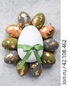 Stylish beautiful Easter eggs with golden potali coating on a gray background. The concept of happy Easter 2024. Стоковое фото, фотограф Photojuli / Фотобанк Лори