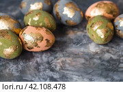 Stylish beautiful Easter eggs with golden potali coating on a gray background. The concept of happy Easter 2024. Стоковое фото, фотограф Photojuli / Фотобанк Лори