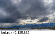 A picturesque mountain range of the Andes against a cloudy sky. In the foreground is the Beagle Channel with rocky islets. Argentina. Patagonia. Tierra del Fuego Archipelago. Стоковое фото, фотограф Вера Ивановна Кубарева / Фотобанк Лори
