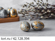 Stylish grey Easter eggs made of marble and concrete with a golden potala on a grey background. Coloring eggs with natural dye karkade tea. . The concept of a happy Easter. Стоковое фото, фотограф Photojuli / Фотобанк Лори