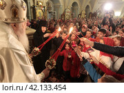 Пасха 2018 года в Успенском храме Новодевичьего монастыря, Москва. Митрополит Ювеналий раздаёт благодатный огонь. Редакционное фото, фотограф Дмитрий Неумоин / Фотобанк Лори