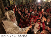 Пасха 2018 года в Успенском храме Новодевичьего монастыря, Москва. Митрополит Ювеналий раздаёт благодатный огонь. Редакционное фото, фотограф Дмитрий Неумоин / Фотобанк Лори