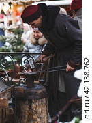 Moscow seasons. A traditional craft. Blacksmith's work with metal. Russian traditions. Hammer and anvil. Moscow. Russia (2023 год). Редакционное фото, фотограф Photojuli / Фотобанк Лори