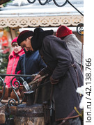 Moscow seasons. A traditional craft. Blacksmith's work with metal. Russian traditions. Hammer and anvil. Moscow. Russia (2023 год). Редакционное фото, фотограф Photojuli / Фотобанк Лори