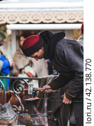 Moscow seasons. A traditional craft. Blacksmith's work with metal. Russian traditions. Hammer and anvil. Moscow. Russia (2023 год). Редакционное фото, фотограф Photojuli / Фотобанк Лори