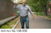 An angry bully with a baseball bat in his hands attacking. Стоковое видео, видеограф Chudakov_Ivan / Фотобанк Лори