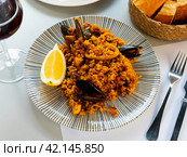 Racy seafood paella with mussels, squid rings and lemon. Стоковое фото, фотограф Яков Филимонов / Фотобанк Лори