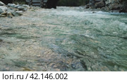 A swift mountain river with a powerful current. A majestic mountain river rushing through a beautiful natural setting, throwing up spray. Evening light. Стоковое видео, видеограф Воловодов Владимир / Фотобанк Лори