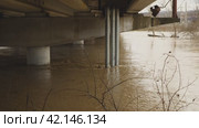 Water in the river coming up to the top of the bridge. Flooding. Thick concrete piers under water. Muddy river after heavy rain and melting snow. Natural disasters. Environmental disaster. Стоковое видео, видеограф Воловодов Владимир / Фотобанк Лори