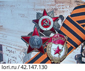 Ордена «Красной Звезды» и «Отечественной войны», знак «Гвардия», георгиевская лента на фронтовой фотографии. Награды фронтовика. Семейная реликвия. Память. 9 мая День Победы. Стоковое фото, фотограф Сергей Елизарьев / Фотобанк Лори