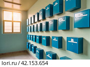 Blue steel Mailboxes in an apartment residential building inside. Modern rows of numbered mailbox, creative design mail backgrounds. Urban correspondence concept. Copy ad text space. Generated Ai. Стоковое AI-изображение, AI-художник Aleksandr Golubev / Фотобанк Лори