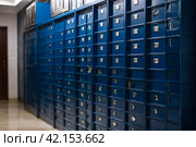 Blue steel Mailboxes in an apartment residential building inside. Modern rows of numbered mailbox, creative design mail backgrounds. Urban correspondence concept. Copy ad text space. Generated Ai. Стоковое AI-изображение, AI-художник Aleksandr Golubev / Фотобанк Лори