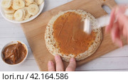 Spread thin pancakes with chocolate or cream paste. Pancakes with boiled condensed milk and banana filling. Стоковое видео, видеограф Глущенко Елена / Фотобанк Лори