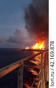 Fire on an offshore oil tanker. Стоковое AI-изображение, AI-художник Кирилл Черезов / Фотобанк Лори