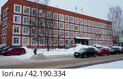 Petrozavodsk, Russia January 22, 2024: Administration of the Prionezhsky municipal district. Pravda Street with snowdrifts, birch trees and parked cars. Red brick building. Local authorities. Редакционное видео, видеограф Юлия Петровская / Фотобанк Лори