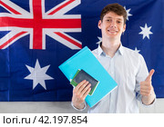 Young guy posing with documents against background of Australian flag. Стоковое фото, фотограф Татьяна Яцевич / Фотобанк Лори
