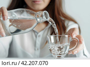 Девушка аккуратно наливает из пластиковой бутылки чистую воду в стеклянный стакан. Стоковое AI-изображение, AI-художник Щеголева Ольга / Фотобанк Лори