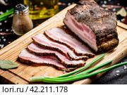 Pieces of pork lard on a cutting board with green onions and bay leaves. Стоковое фото, фотограф Артем Шадрин / Фотобанк Лори
