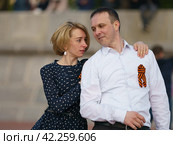 Moscow, Russia - May 9, 2022: Cheerful Dancing couple of young man and woman in public park. Lifestyle theme. Having fun people. People celevrate Victory Day, the win in the Great Patriotic War. Редакционное фото, фотограф YuryKara / Фотобанк Лори