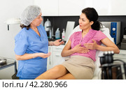 Woman asking cosmetologist about breast lift and reshaping procedures. Стоковое фото, фотограф Яков Филимонов / Фотобанк Лори