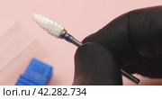 A specialist holds in his hands a ceramic cutter for hardware manicure with a blue notch for removing gel polish from nails. Стоковое видео, видеограф Сергей Чайко / Фотобанк Лори