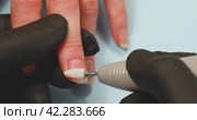 A nail salon specialist performs hardware removal of rough skin on the hands using a ceramic cutter. Стоковое видео, видеограф Сергей Чайко / Фотобанк Лори
