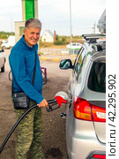 elderly man tourist refueling his car for traveling around his home country. Стоковое фото, фотограф Акиньшин Владимир / Фотобанк Лори