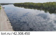 Blue skies with clouds reflected in the smooth surface of the dark river. View from above. A beautiful landscape. White clouds mirroring the surface of the water. Стоковое видео, видеограф Воловодов Владимир / Фотобанк Лори