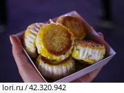 Уличная еда – китайские пельмени дим сам с мясом в сиреневой коробочке, держит женская рука. Сиань. Китай (2019 год). Стоковое фото, фотограф Елена Яворская / Фотобанк Лори