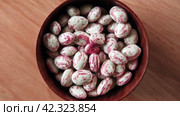 Cranberry beans spinning. Borlotti bean pods in wooden bowl. Top view. Stylish modern food background. Magenta color. Creative foodstuff flat lay. Grocery, dietary backdrop. Advertising, trendy video. Стоковое видео, видеограф Марина Демидюк / Фотобанк Лори