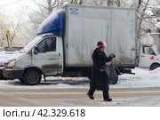 Женщина зимой переходит дорогу (2018 год). Редакционное фото, фотограф Дмитрий Неумоин / Фотобанк Лори
