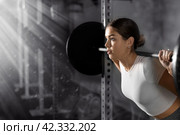 Caucasian woman training with barbell using squat rack in crossfit gym. Стоковое фото, фотограф Яков Филимонов / Фотобанк Лори