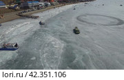 A hovercraft transports tourists across the ice of Lake Baikal. Listvyanka village, a popular tourist destination. Стоковое видео, видеограф Виктория Тельминова / Фотобанк Лори